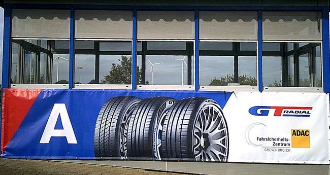 Das Bild zeigt das Modulhäuschen A mit dem Werbebanner unseres Reifenpartners GT Radial, dessen Firmenlogos und unseres.
